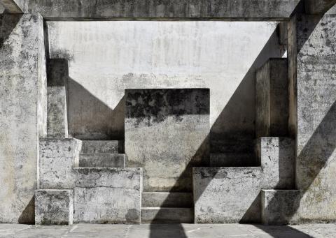 Photograph taken in Granada, Spain, showing light falling across block-like structures, creating geometric shadows.